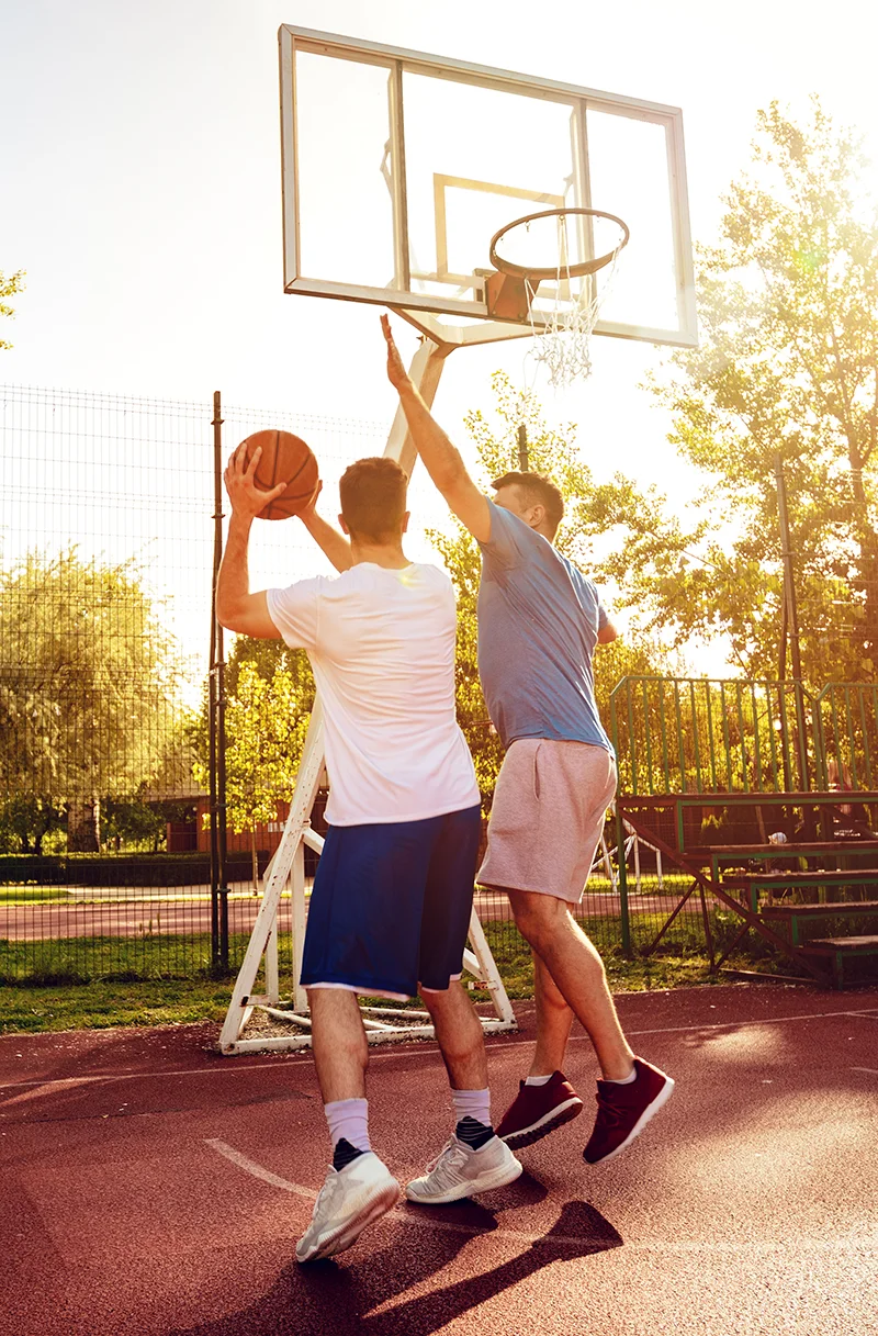 The Tummy Team - Diastasis Recti And Pelvic Floor Healing 3 Two men playing basketball outdoors, illustrating restored strength and mobility through core rehabilitation for diastasis recti in men.